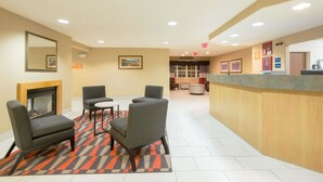 A lobby with a reception desk, seating area, and a fireplace. - Microtel Inn & Suites by Wyndham Pueblo (Pueblo)
