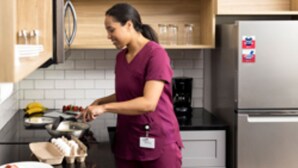 Een keuken met houten kastjes, een roestvrijstalen koelkast en een koffiezetapparaat.