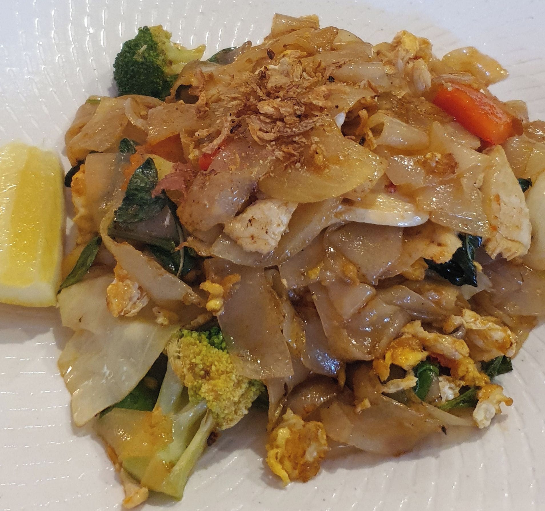 Une assiette de Pad Thaï aux légumes et aux crevettes.