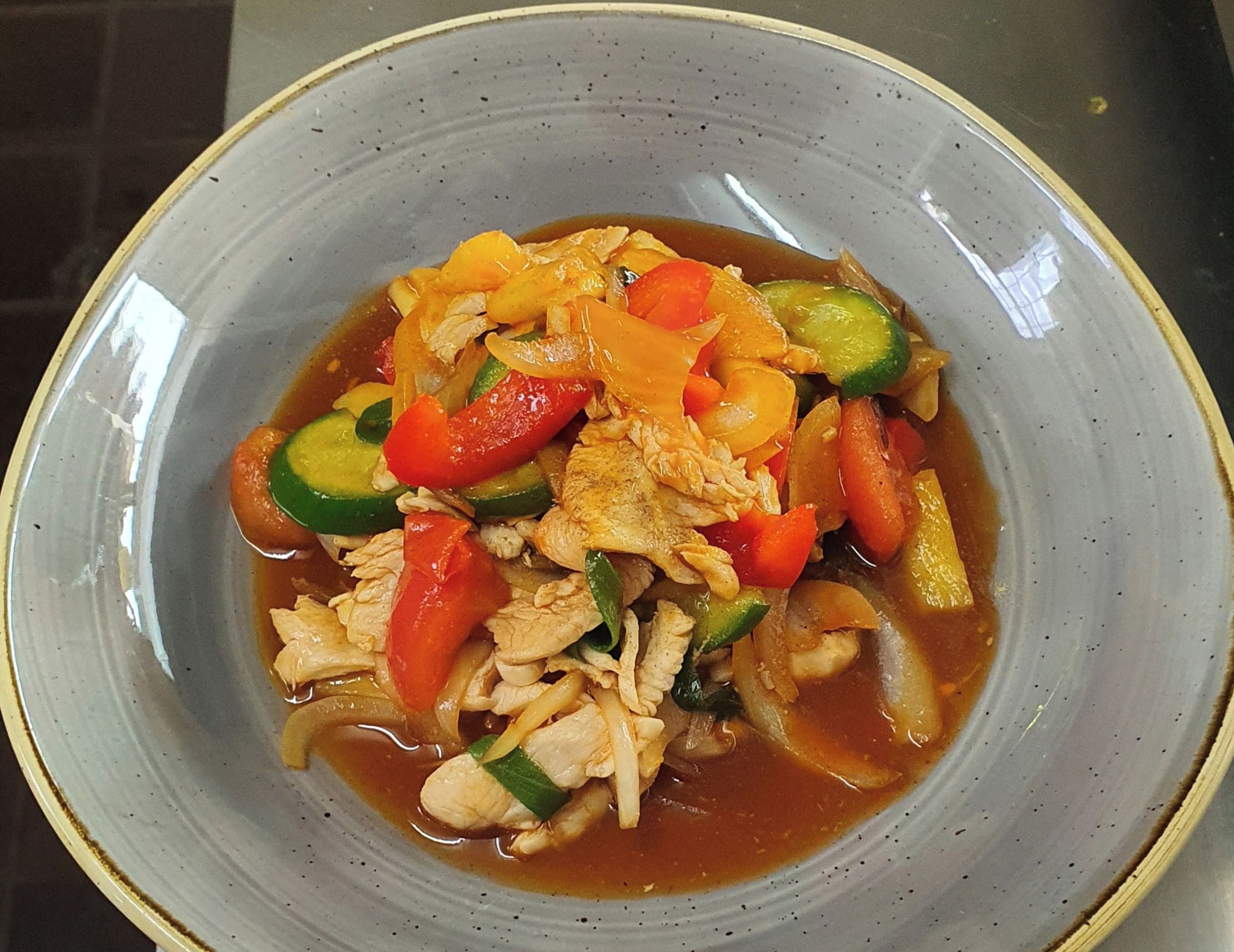 A bowl of Sweet & Sour Chicken with vegetables.