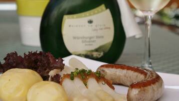 A plate with food and a bottle of wine on a table.