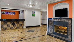Un hall d’entrée avec un comptoir d’enregistrement, une cheminée et un téléviseur fixé au-dessus.