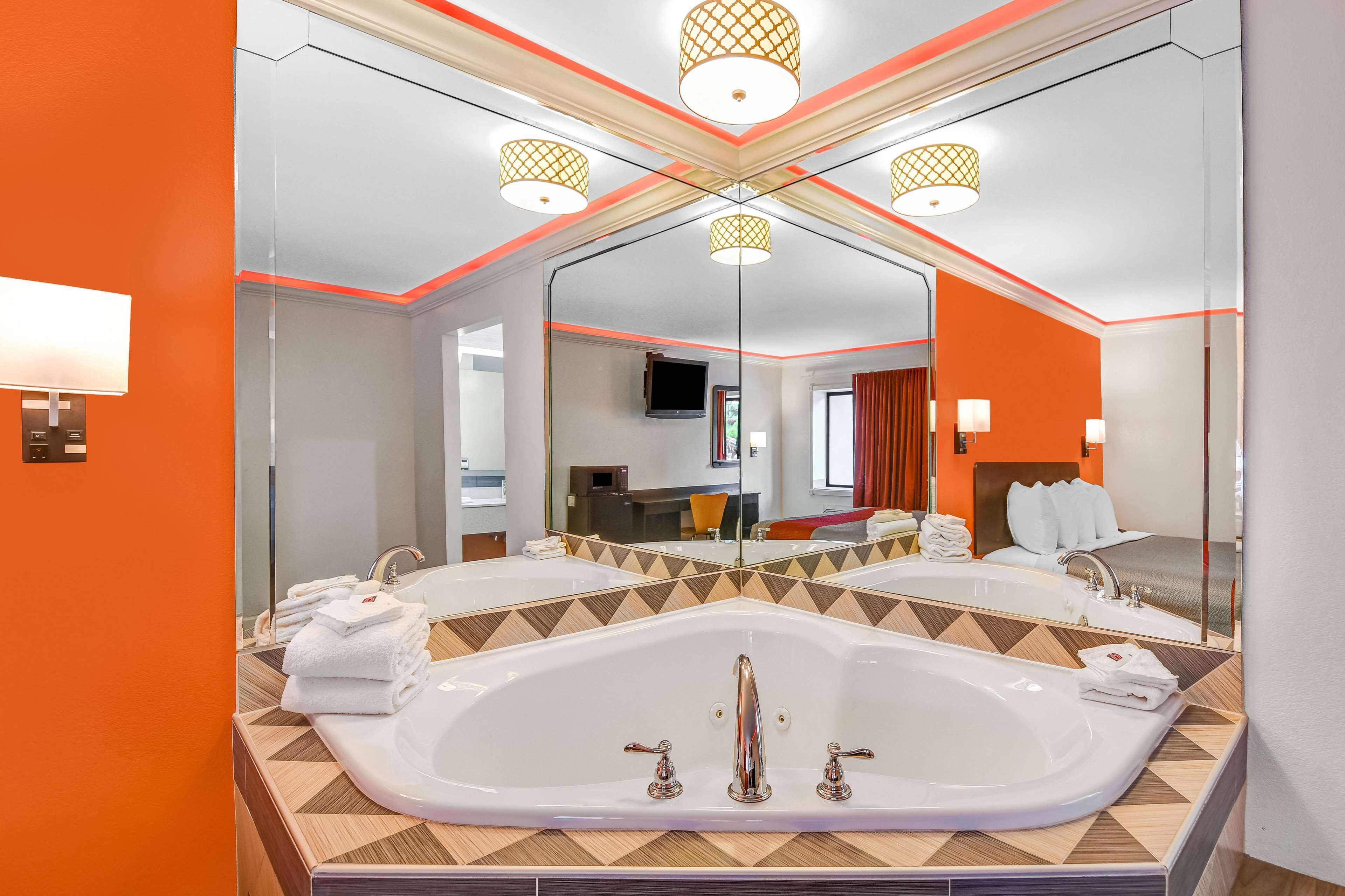 Een moderne badkamer met een grote spiegel, twee wasbakken en een bad.