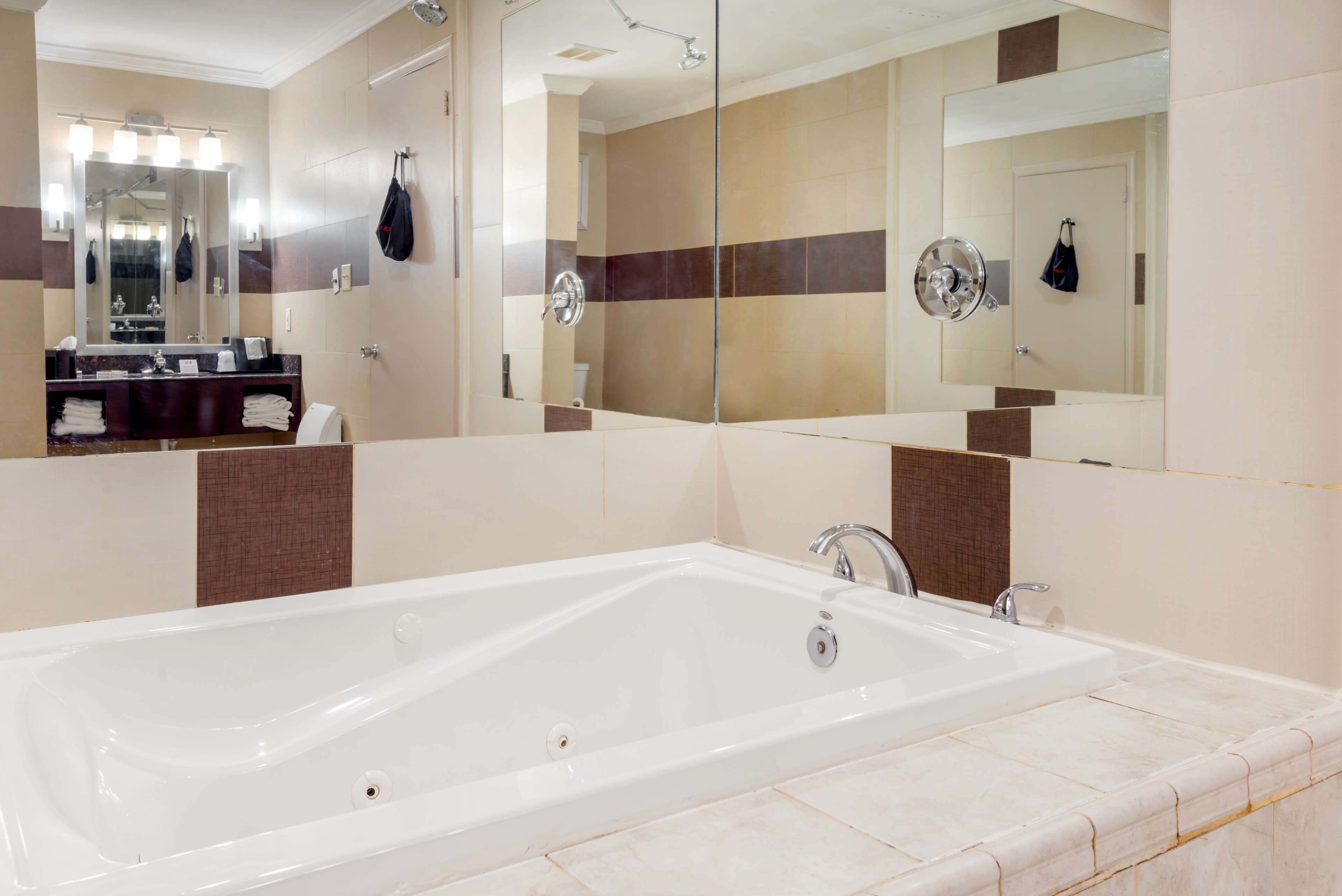 A modern bathroom with a large bathtub, a vanity with a mirror, and a shower area.