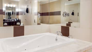 Een moderne badkamer met een groot bad, een wastafel met spiegel en een douche.