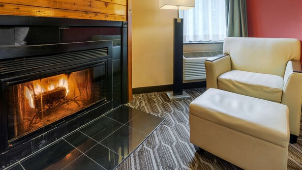 Una habitación moderna con chimenea, un sofá y una lámpara.