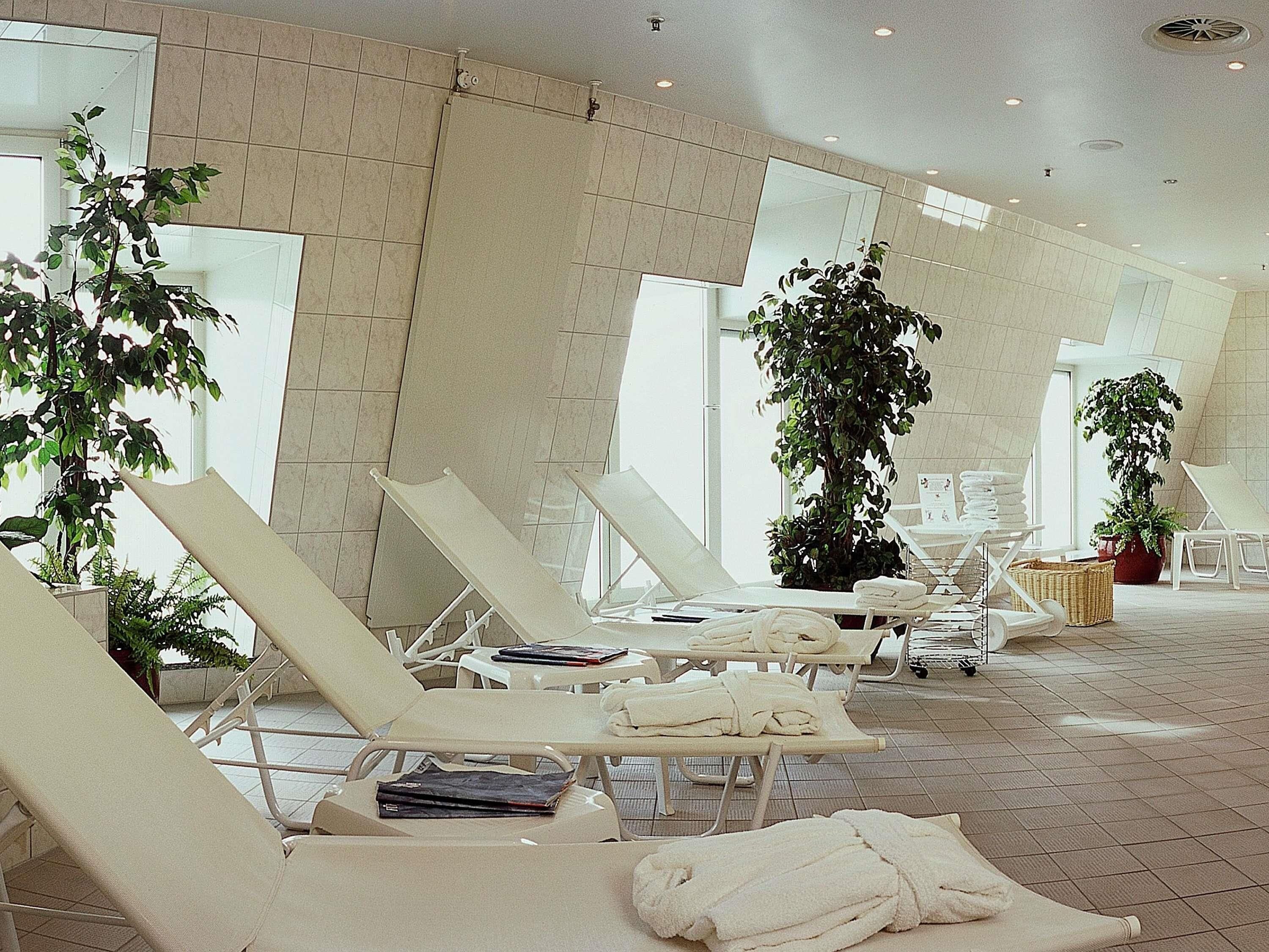 Ein Wellnessbereich mit Liegestühlen, Handtüchern und Topfpflanzen.