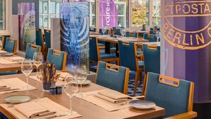 Un restaurante con mesas dispuestas para comer, sillas y vistas al exterior.
