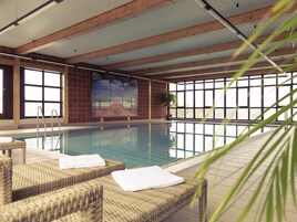 Una piscina techada, sillones reclinables de piscina