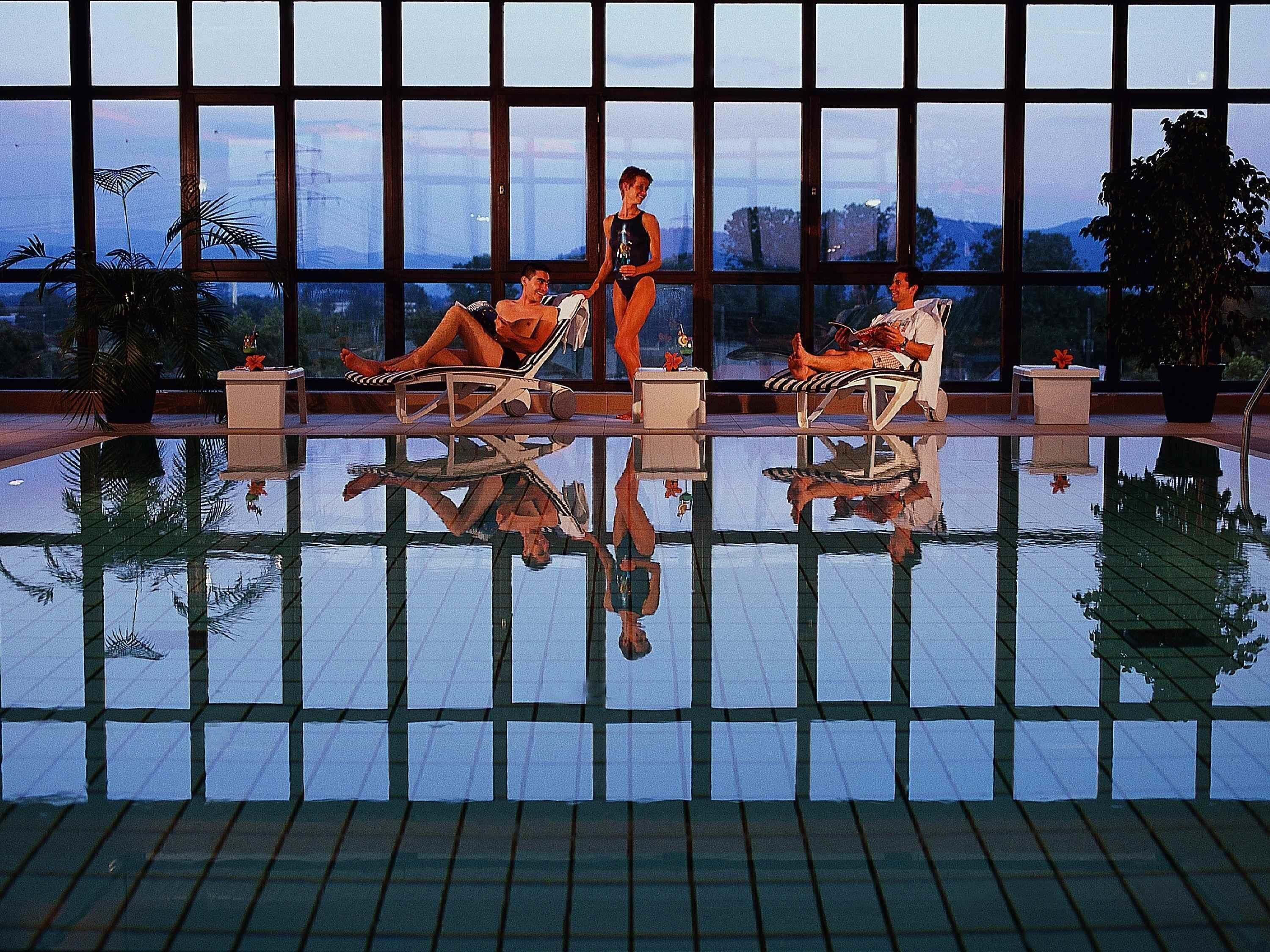 Una piscina techada, sillones reclinables de piscina