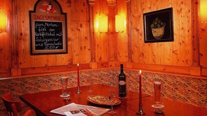 A wooden-paneled room with a table set for dining, featuring a menu, wine bottle, and glasses. - Mercure Hotel Offenburg am Messeplatz (Offenburg)