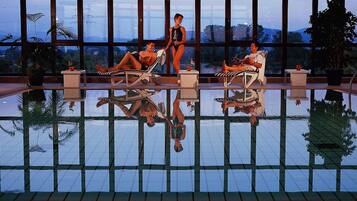 Una piscina cubierta, tumbonas