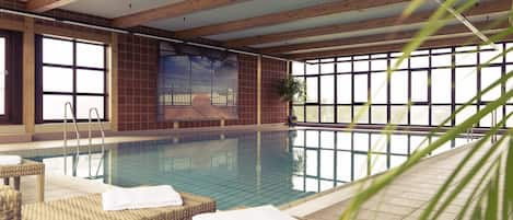 Una piscina techada, sillones reclinables de piscina