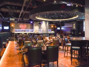 A bar area with leather chairs, a bar counter, and a ceiling with a circular light fixture. - Novotel Ambassador Seoul Gangnam (Seoul)