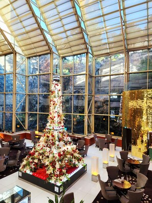 A spacious indoor area with a large glass ceiling, a central floral arrangement, and seating areas. - Novotel Ambassador Seoul Gangnam (Seoul)