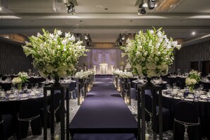 A banquet hall with a long table set for a formal event, flanked by tall floral arrangements and candle-lit centerpieces. - Novotel Ambassador Seoul Gangnam (Seoul)