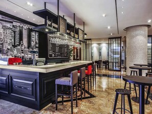 A modern bar area with a menu display, seating arrangements, and a decorative column. - Novotel Ambassador Seoul Gangnam (Seoul)