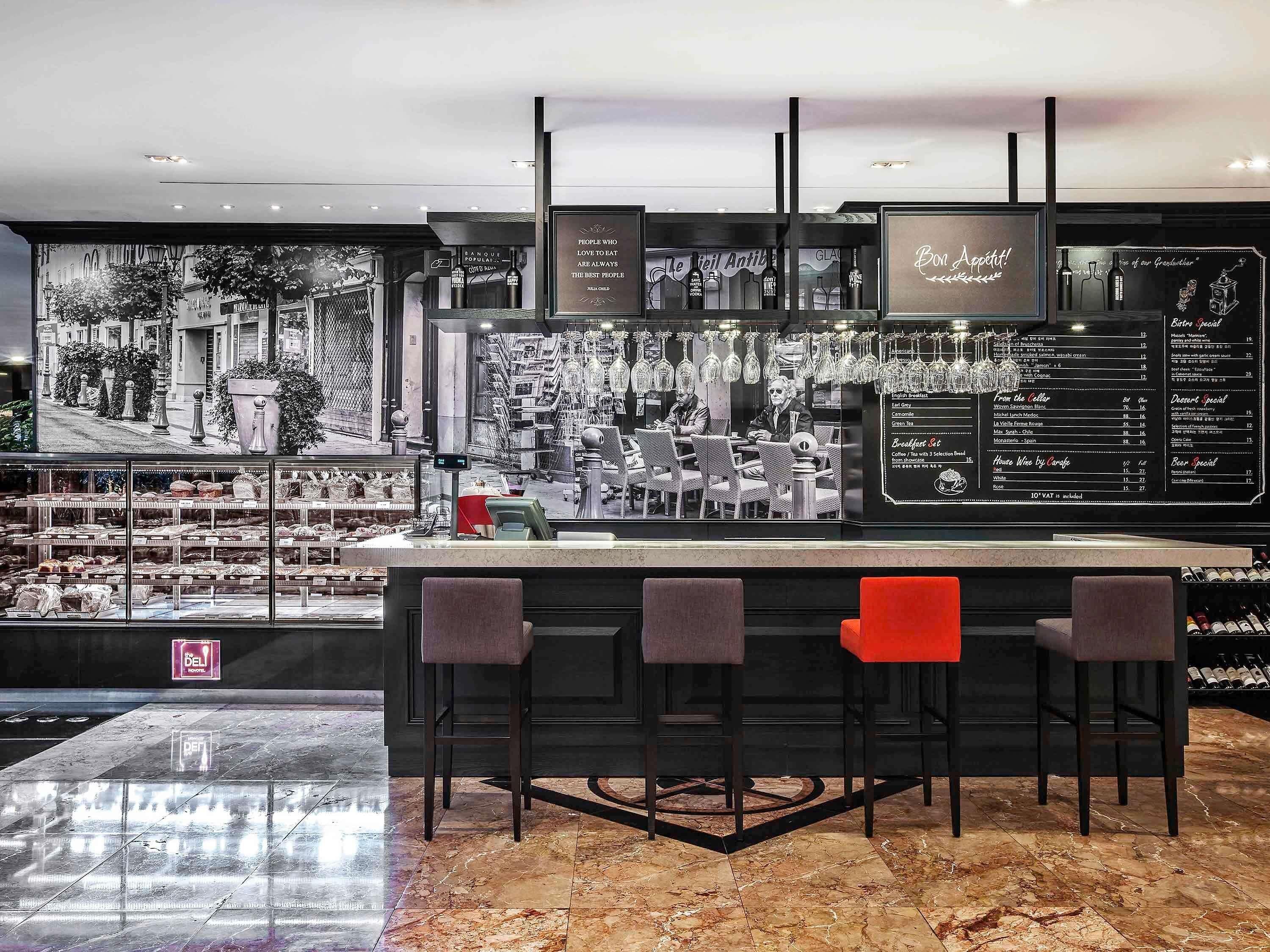 Zona de bar con tablero de menú, asientos y barra.
