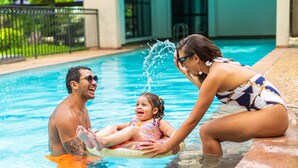 Une piscine avec une personne et un enfant sur un flotteur.