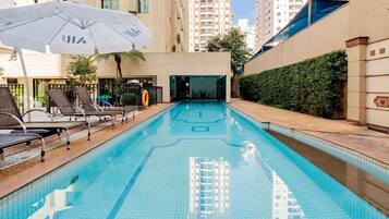 Una piscina al aire libre, tumbonas