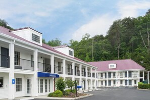 Een motel met een centrale gang, kamers aan weerszijden en een parkeerplaats.