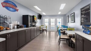 A breakfast area with a counter, seating, and a view of the sea.