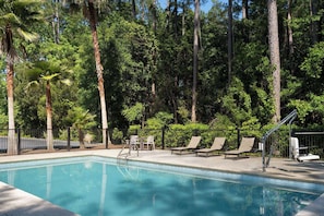 Una piscina al aire libre de temporada, sillones reclinables de piscina