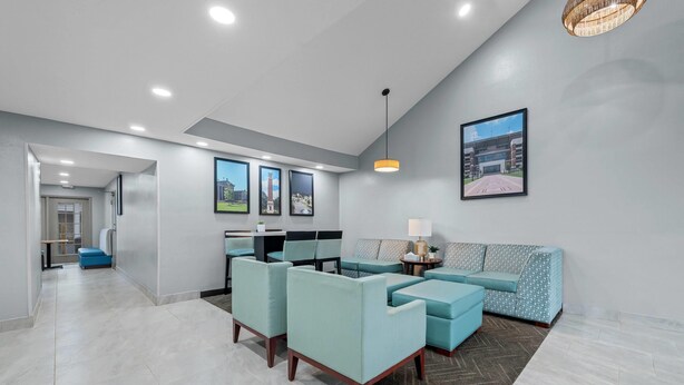 A modern living room with a sofa set, a coffee table, and a lamp. - Baymont by Wyndham Tuscaloosa (Tuscaloosa)