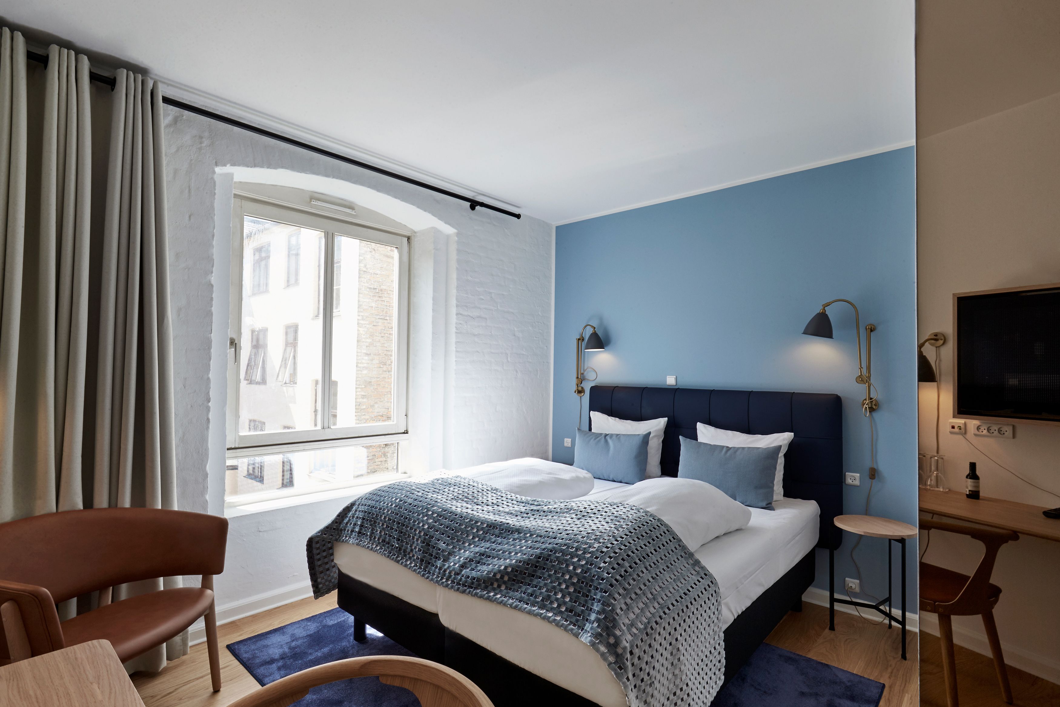 Un dormitorio con una cama grande, un escritorio y una silla.