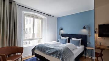 A bedroom with a large bed, a desk, and a chair.
