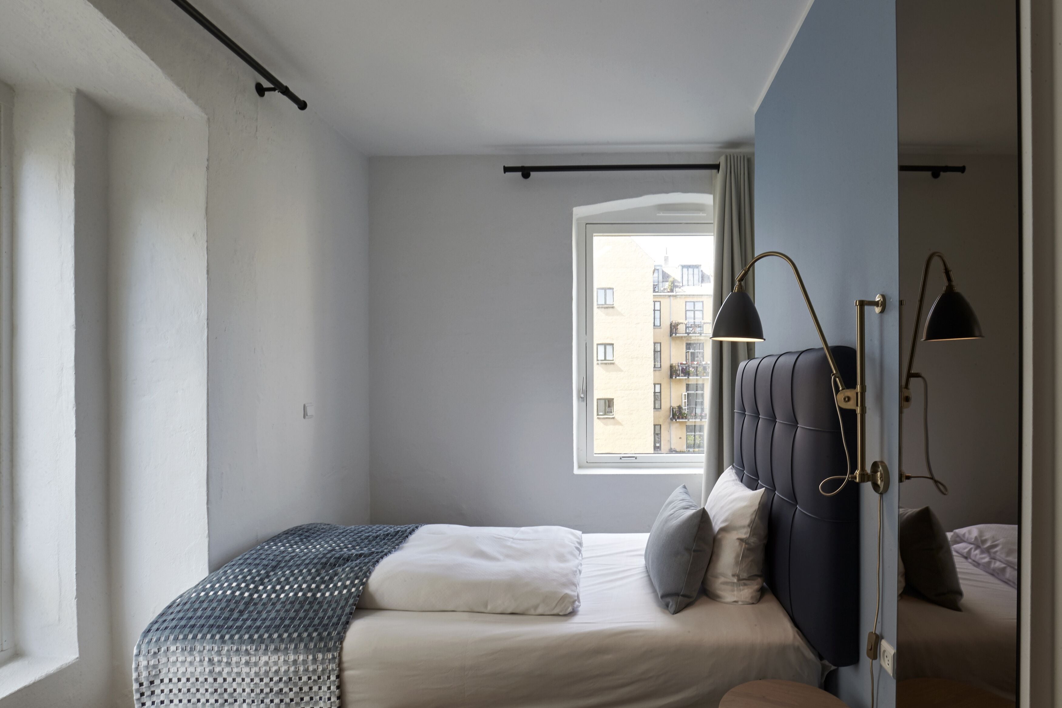 Un dormitorio con una cama, una ventana y una puerta.