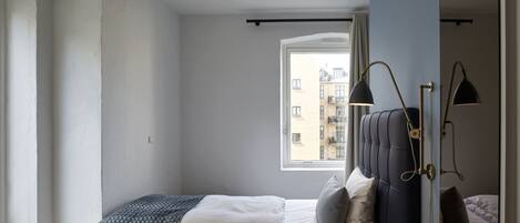 Un dormitorio con una cama, una ventana y una puerta.
