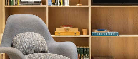 Una estantería con libros, un globo terráqueo y una caja de Scrabble.