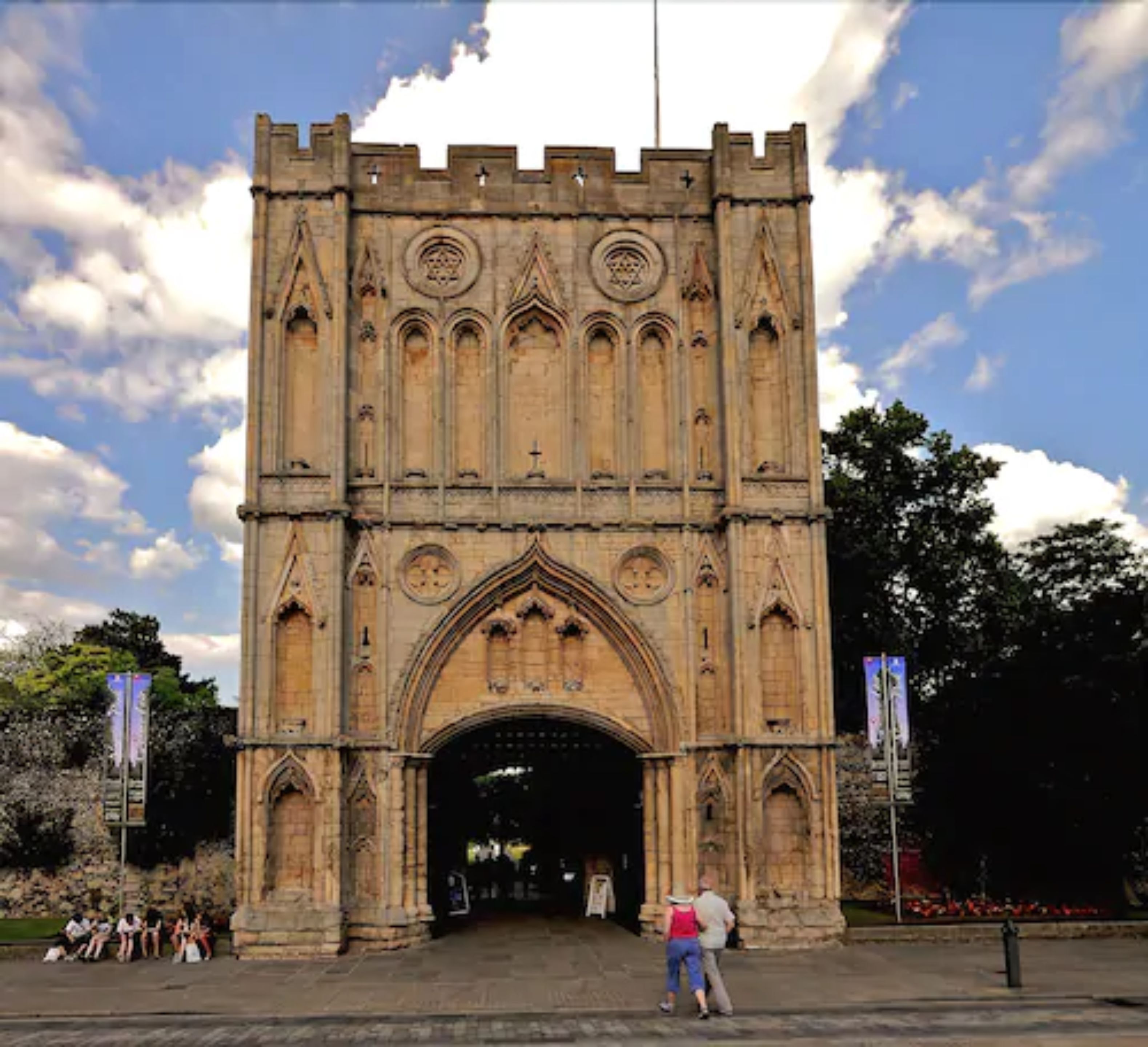 A large stone archway with intricate carvings, leading into a building.