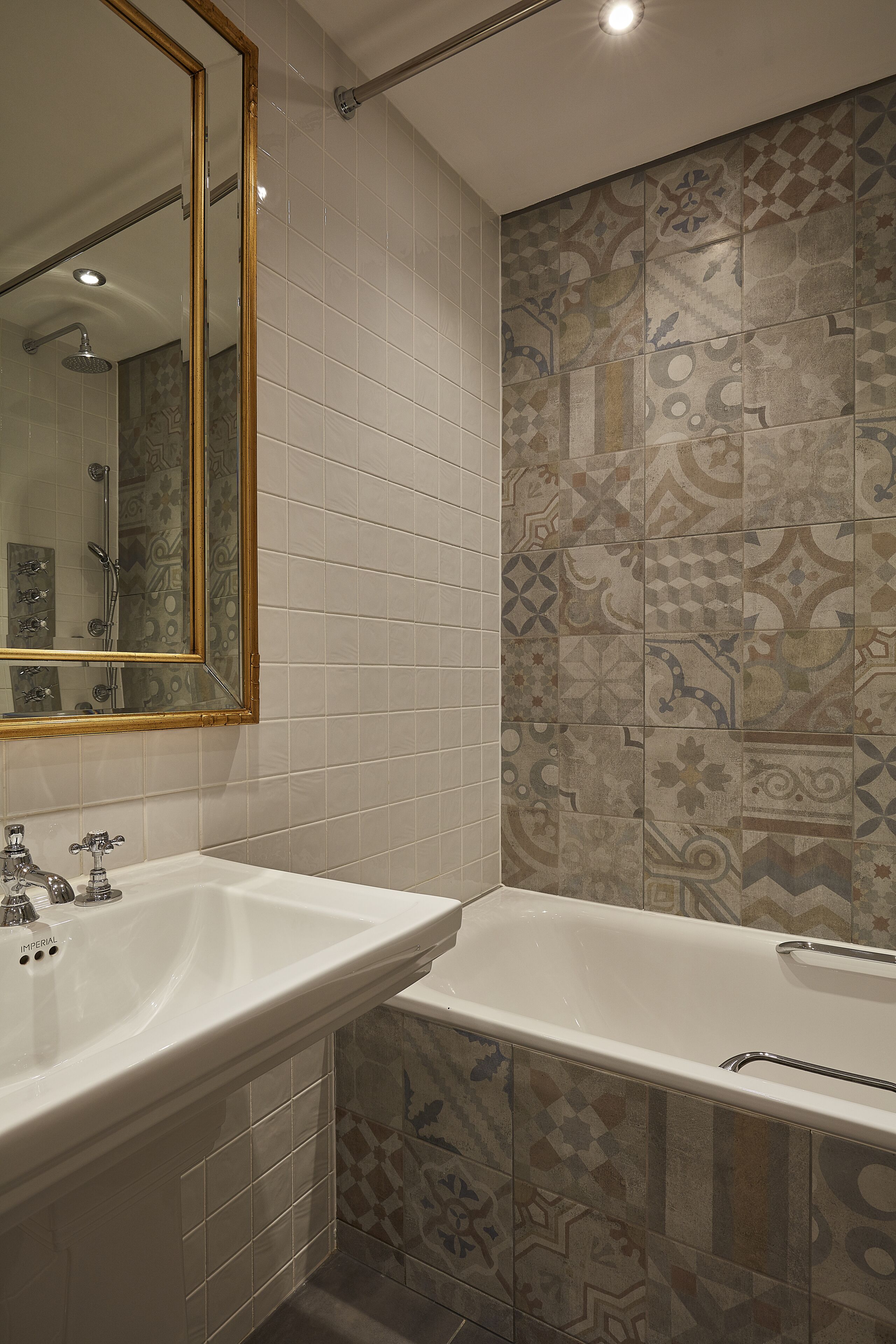 Un baño con un lavabo blanco, una bañera y un espejo grande.