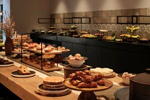 Un bufé con diversos postres y frutas.