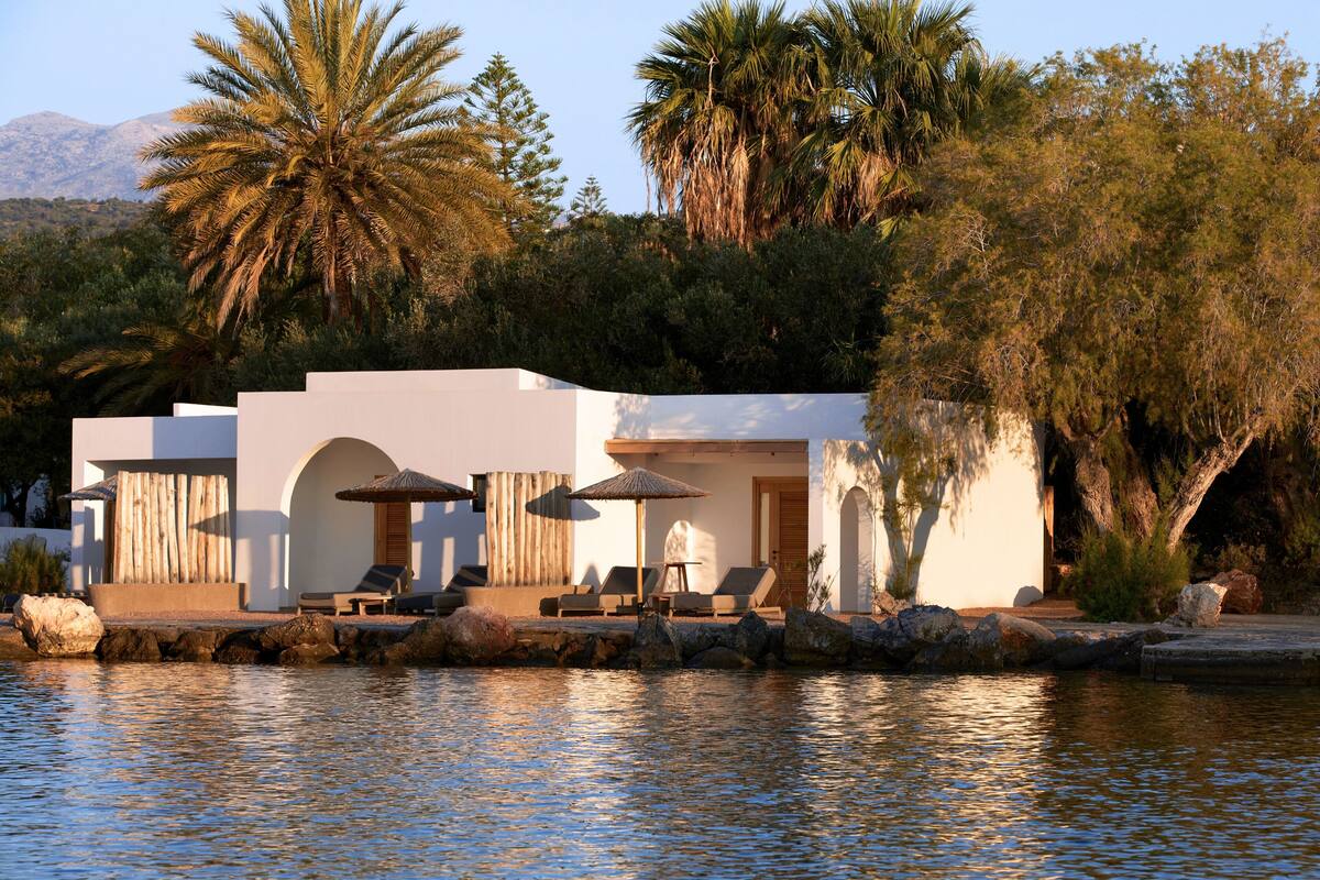 Un resort con piscina, sillas de descanso y sombrillas.