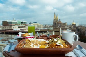 Un repas sur une terrasse avec une vue sur la ville en arrière-plan.