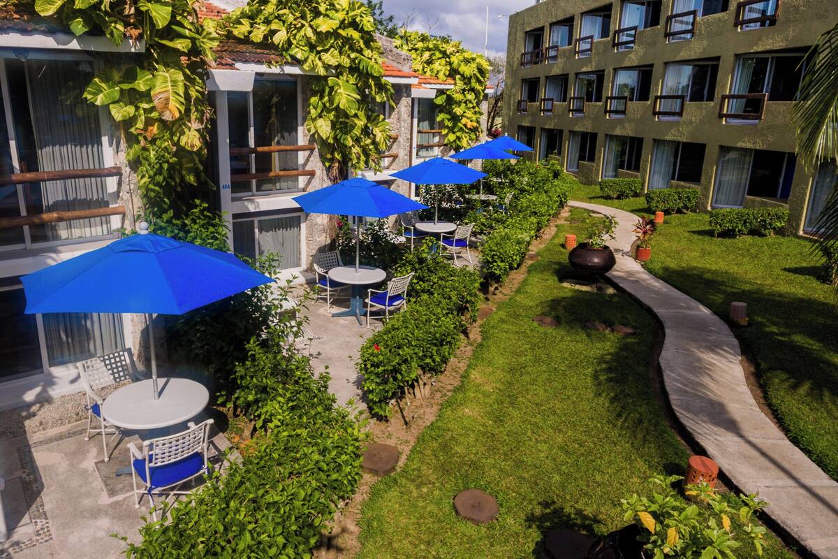 Une cour avec des espaces de repos en plein air, des parasols et un chemin.
