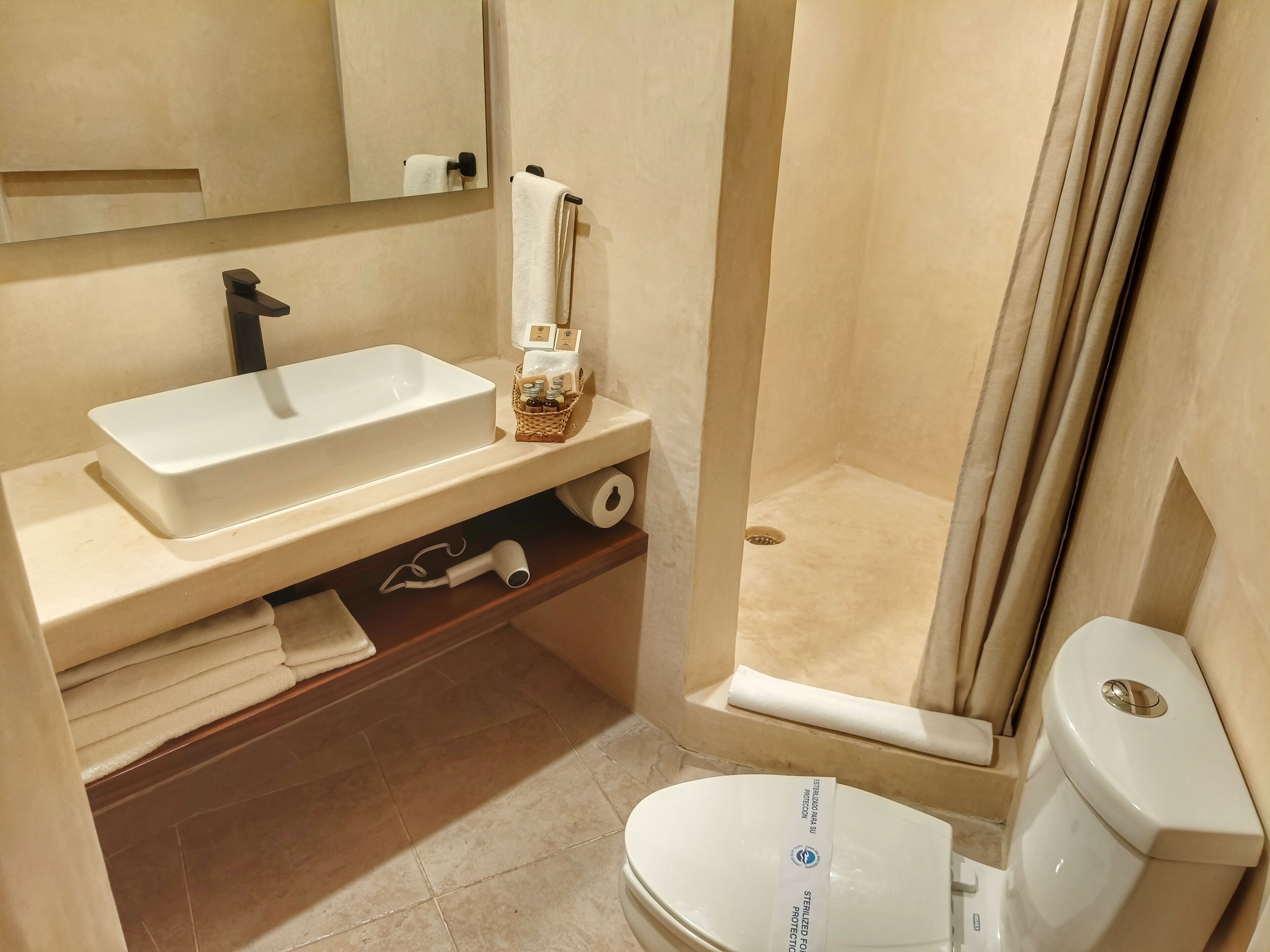 Un bagno con lavandino bianco, un WC e zona doccia.