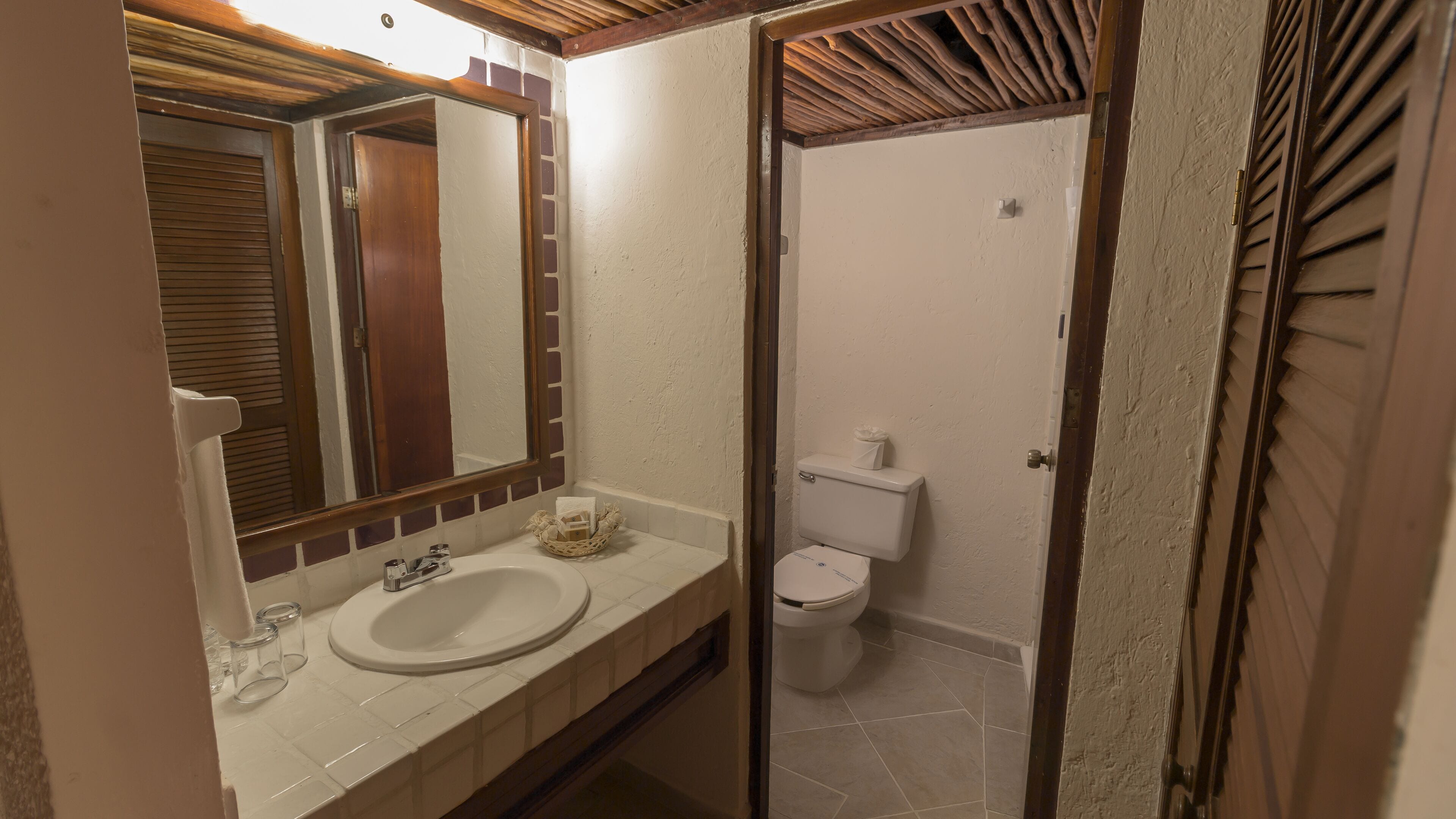 Een badkamer met een wastafel, spiegel en toilet.