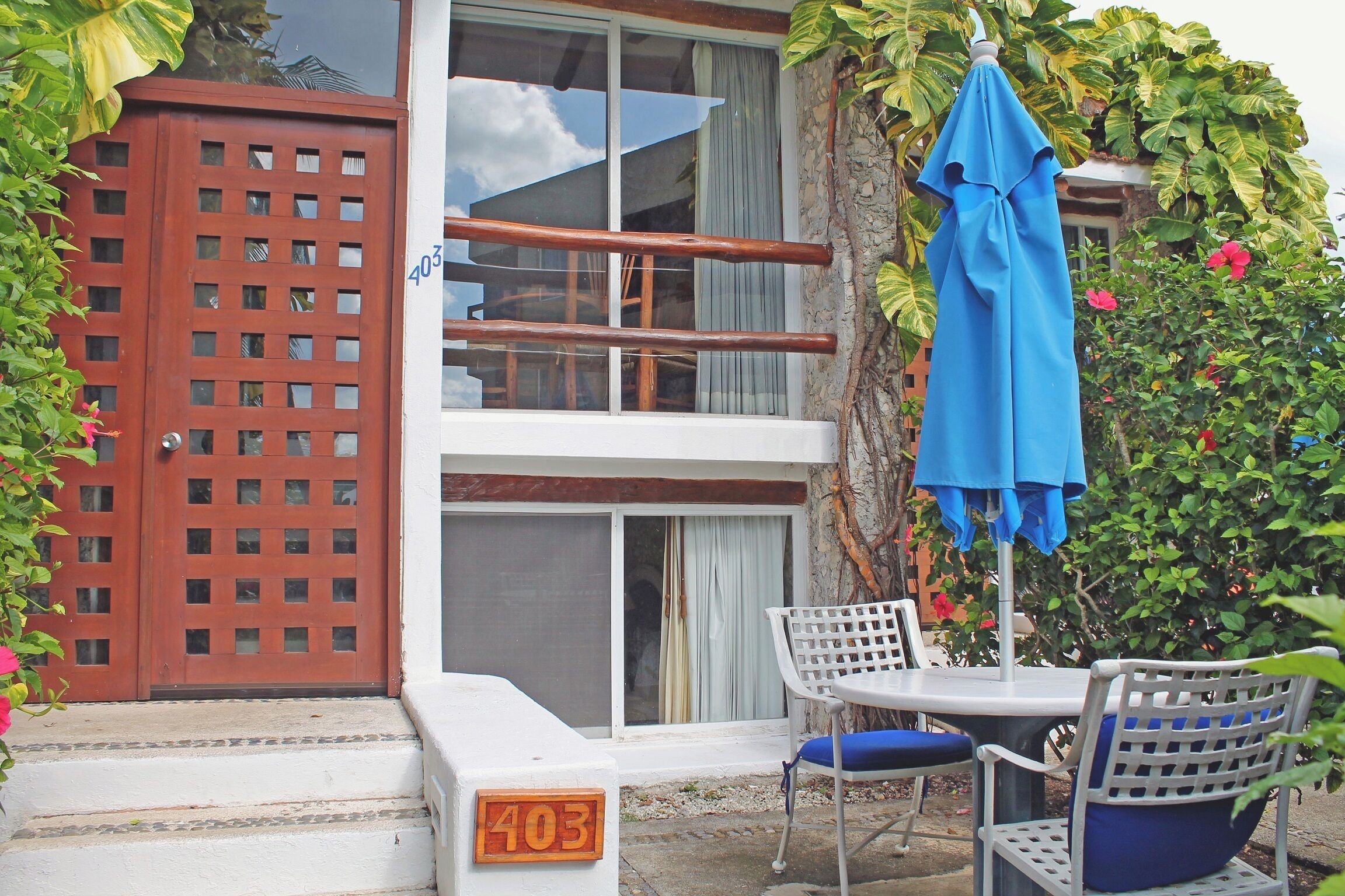 A hotel entrance with a wooden gate, a staircase, and a number '403' sign.