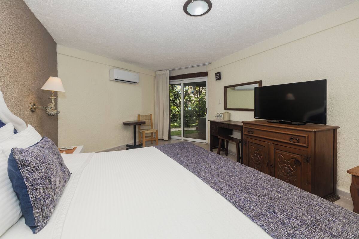 Une chambre d’hôtel équipée d’un lit, d’une télévision, d’un bureau et d’une chaise.