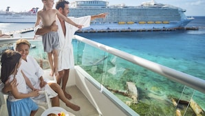 Un balcón con vista al océano y un crucero.