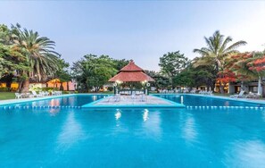 Una piscina al aire libre, sillones reclinables de piscina