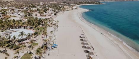 Na praia, areia branca, barracas de praia de cortesia