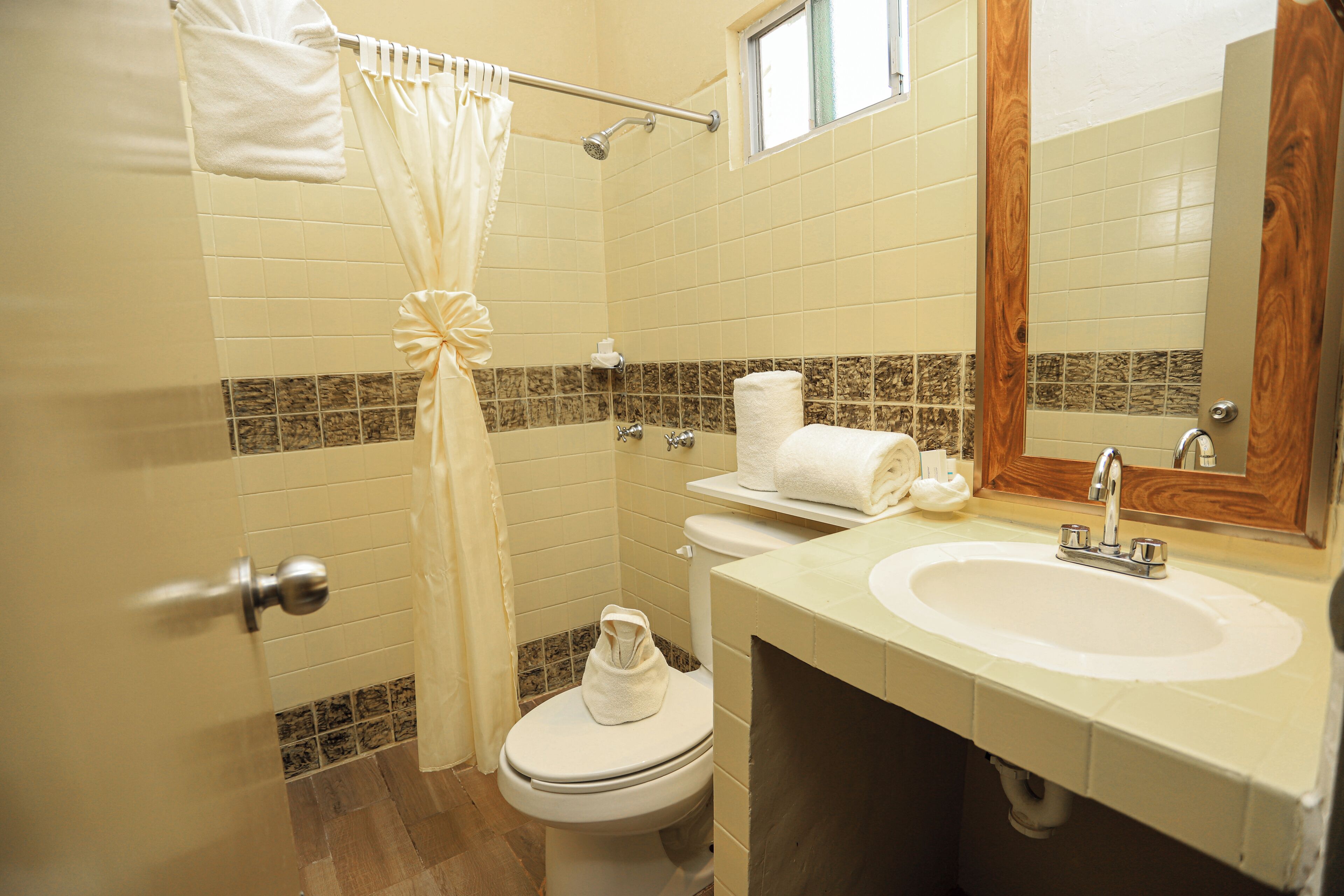 Un baño con inodoro, lavamanos y cortina de ducha.