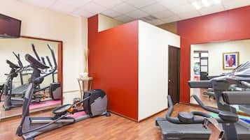A gym with multiple treadmills, a stationary bike, and a mirror wall.