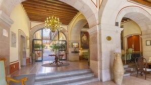 A grand lobby with arched ceilings, a chandelier, a large vase, and a staircase leading to another area. - Hotel Mesón de Jobito (Zacatecas)