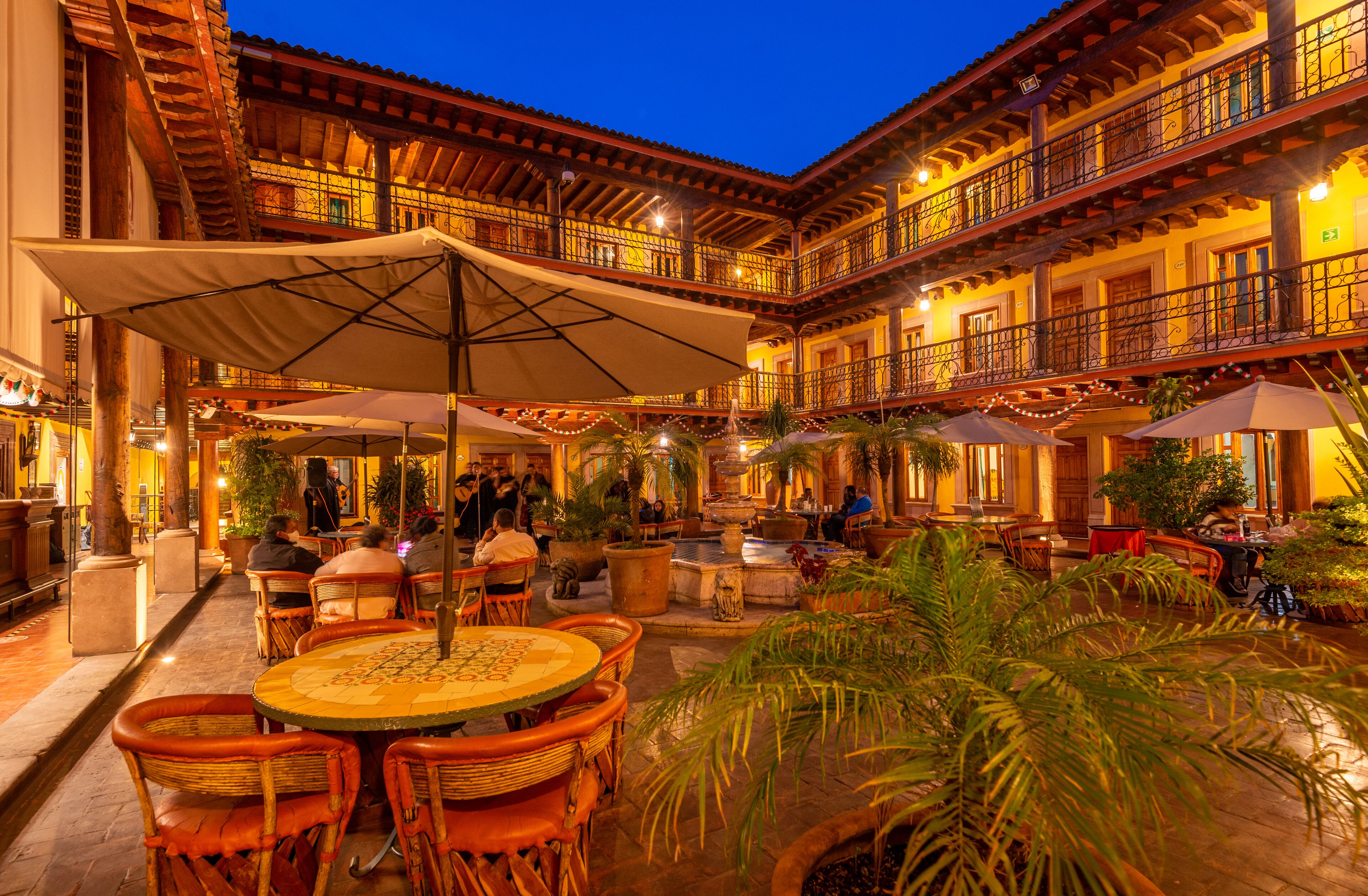 A courtyard with outdoor seating, a fountain, and multiple balconies.